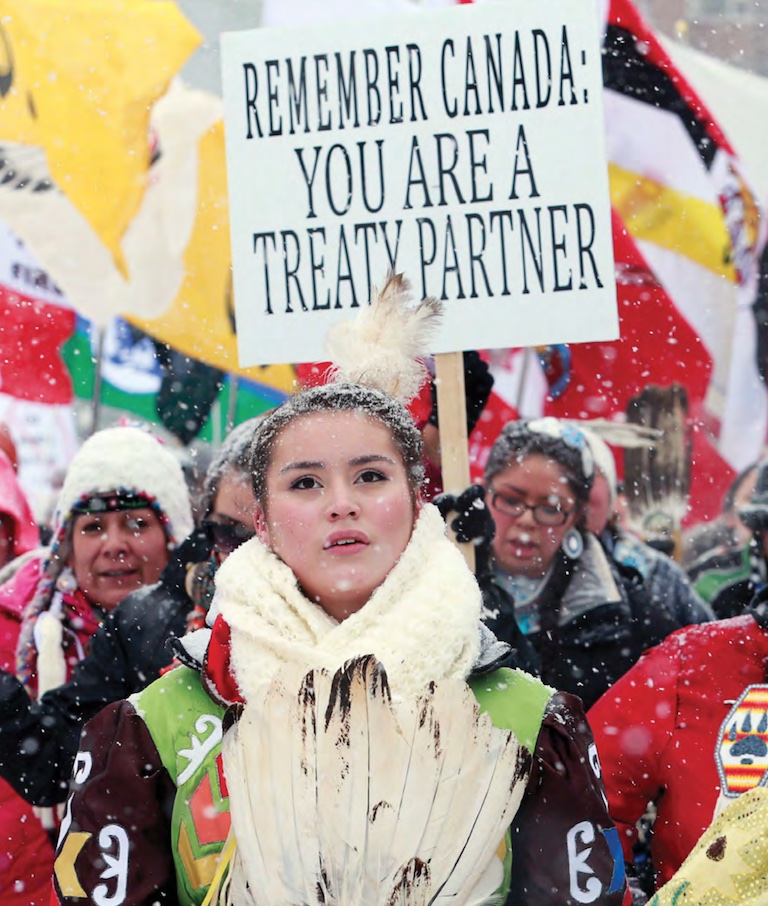 Une femme devant des manifestants en hiver.
