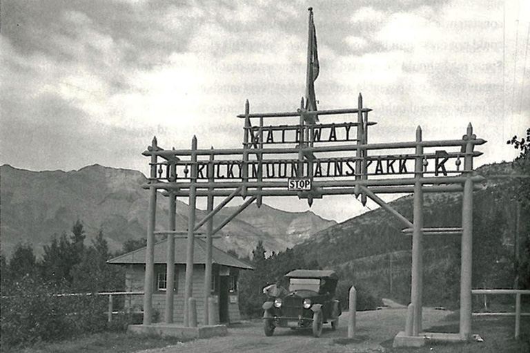 Porte d'entrée du parc des Montagnes-Rocheuses avec les montagnes en arrière.